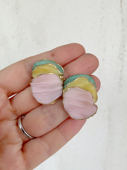 Pendientes de arcilla polimérica de la colección Pétalos en tonos rosa, amarillo y verde menta, con formas orgánicas superpuestas y bordes dorados.