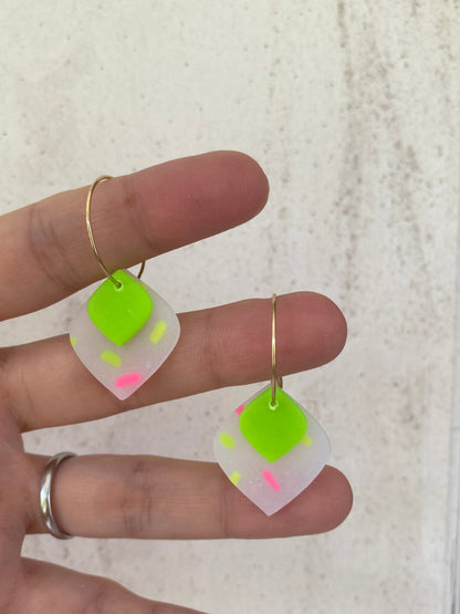 Pendientes geométricos de arcilla polimérica rombos sprinkles neón verde  sobre mano