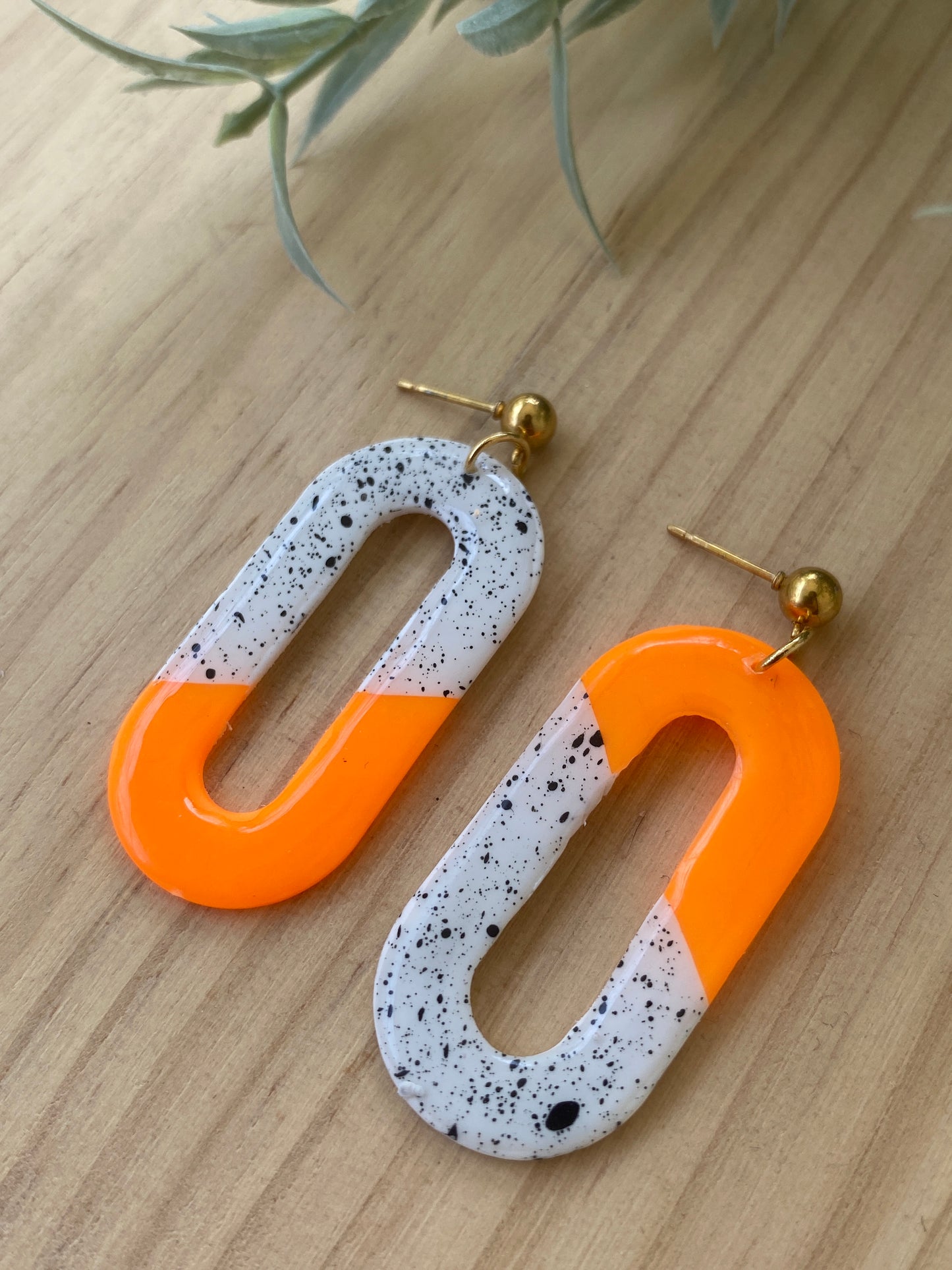 Pendientes ovalados de arcilla polimérica artesanales en color naranja neón bicolor con motas negras – Kitxeti